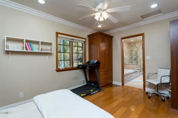 a bedroom with a bed a flat screen tv and a fireplace