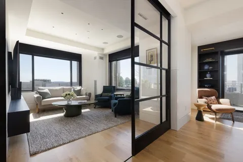 a living room with furniture floor to ceiling window and a table