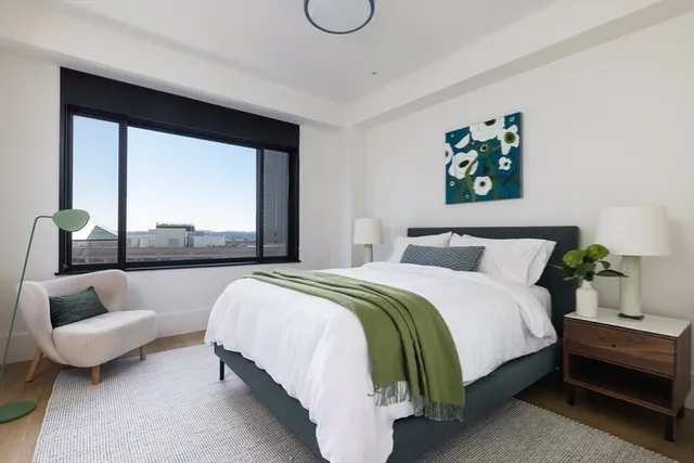 a bedroom with bed and a large window