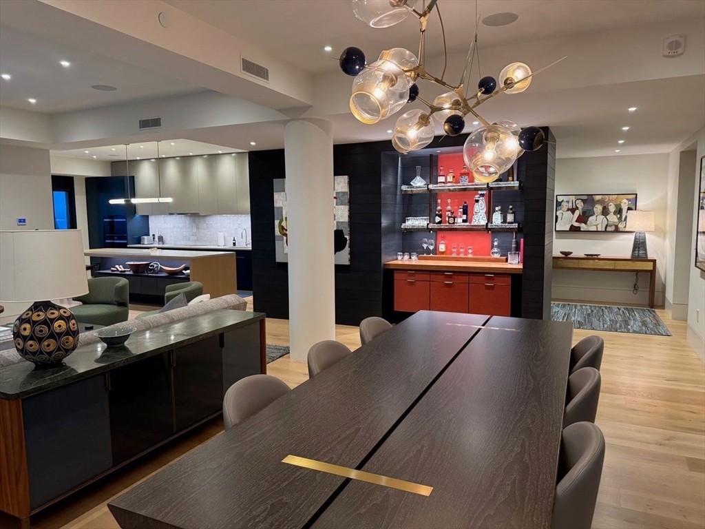 1 Huntington Avenue, Unit 1702 Boston, MA 02116 - Photo 7 of 42 a kitchen with stainless steel appliances kitchen island granite countertop a refrigerator a stove and a sink with wooden floor