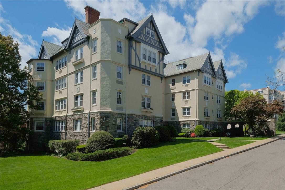 a view of a white building among the yard and a large tree