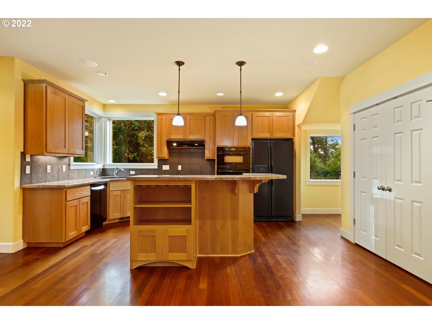 3237 Ridge Pointe Drive Forest Grove, OR 97116 - Photo 8 of 32 a kitchen with kitchen island granite countertop wooden floors and view of living room