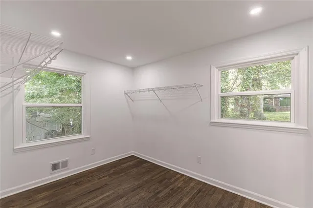 an empty room with wooden floor and windows