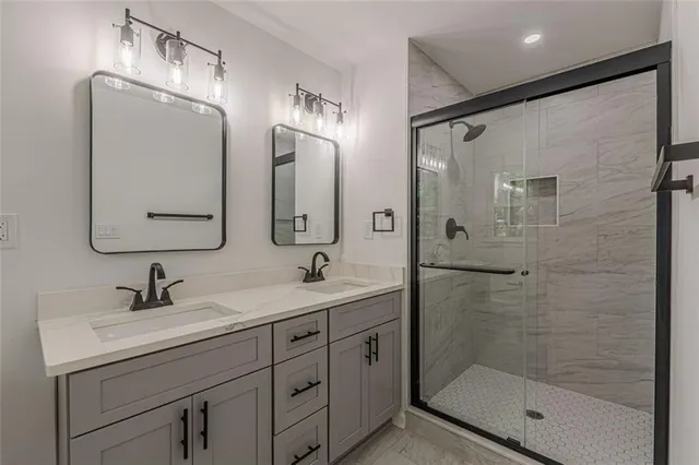a bathroom with a double vanity sink mirror double shower and a mirror