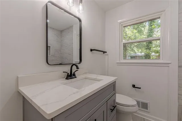 a bathroom with a sink toilet and mirror