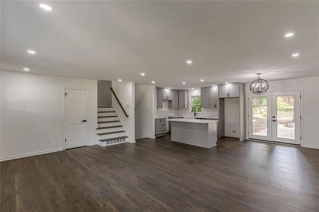 an open kitchen with white cabinets and wooden floor