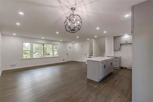 a large kitchen with a large window a sink and a stove top oven