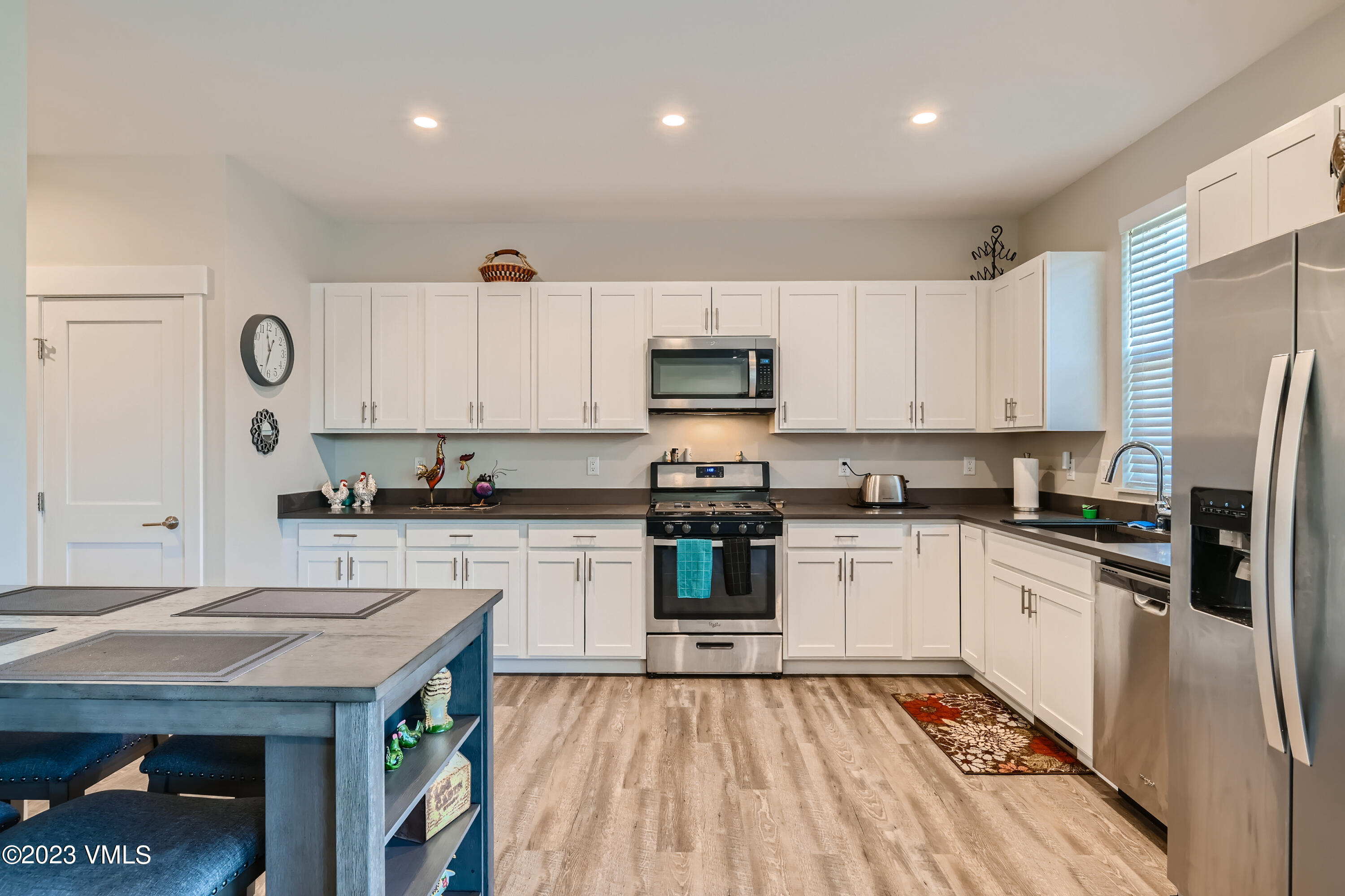 604 Chickadee Lane Gypsum, CO 81637 - Photo 3 of 11 a kitchen with stainless steel appliances granite countertop a refrigerator a stove top oven a sink dishwasher and white cabinets with wooden floor