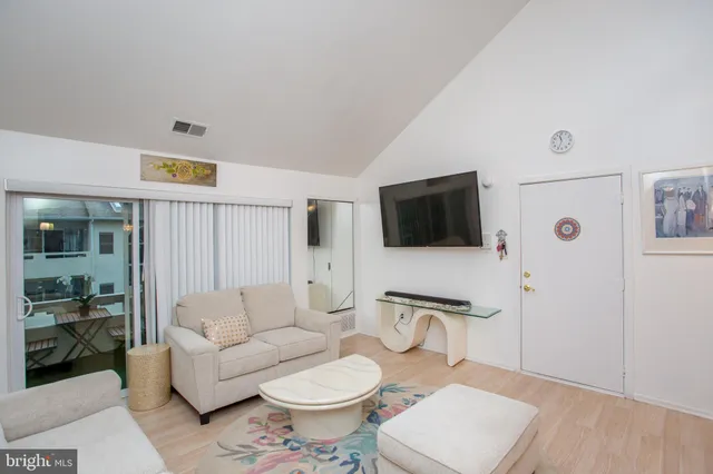 a living room with furniture a rug and a flat screen tv