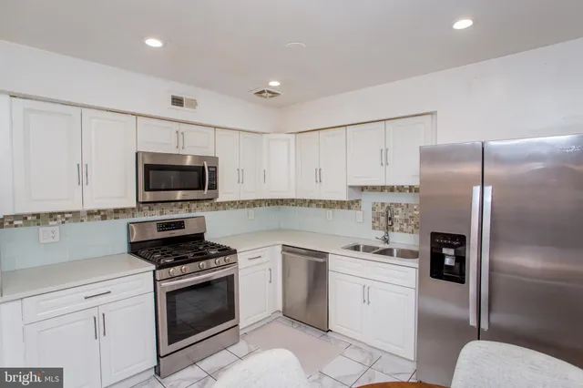 a kitchen with stainless steel appliances a refrigerator and a stove