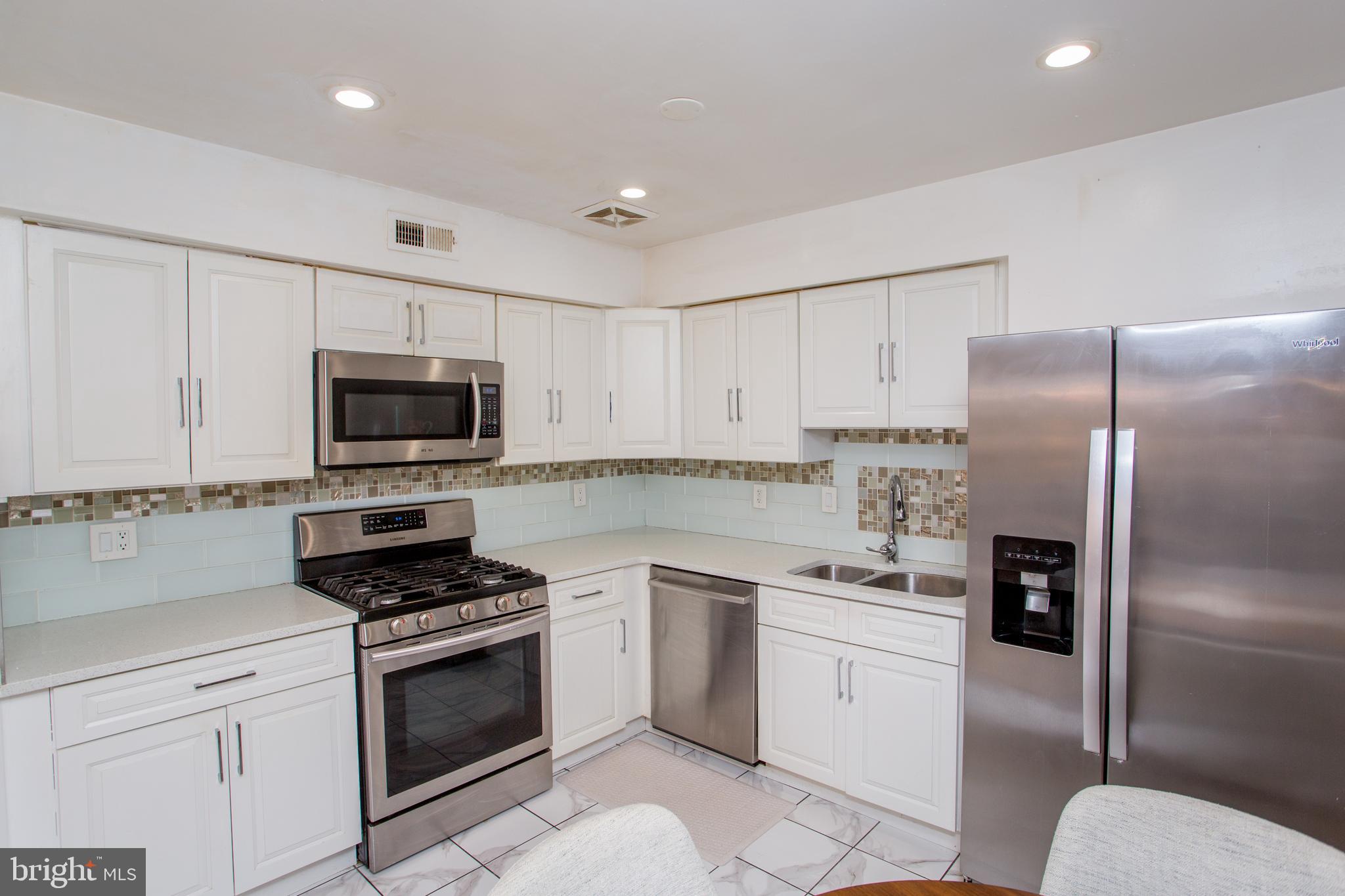 48 Bonnie Gellman Court, Unit B48 Philadelphia, PA 19114 - Photo 20 of 70 a kitchen with white cabinets stainless steel appliances and a sink