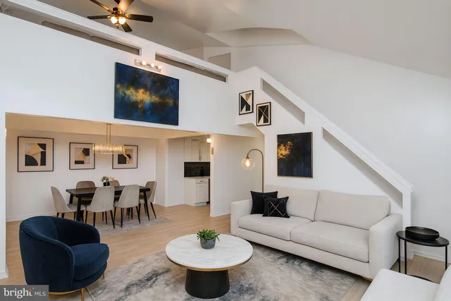 a living room with furniture kitchen view and a flat screen tv