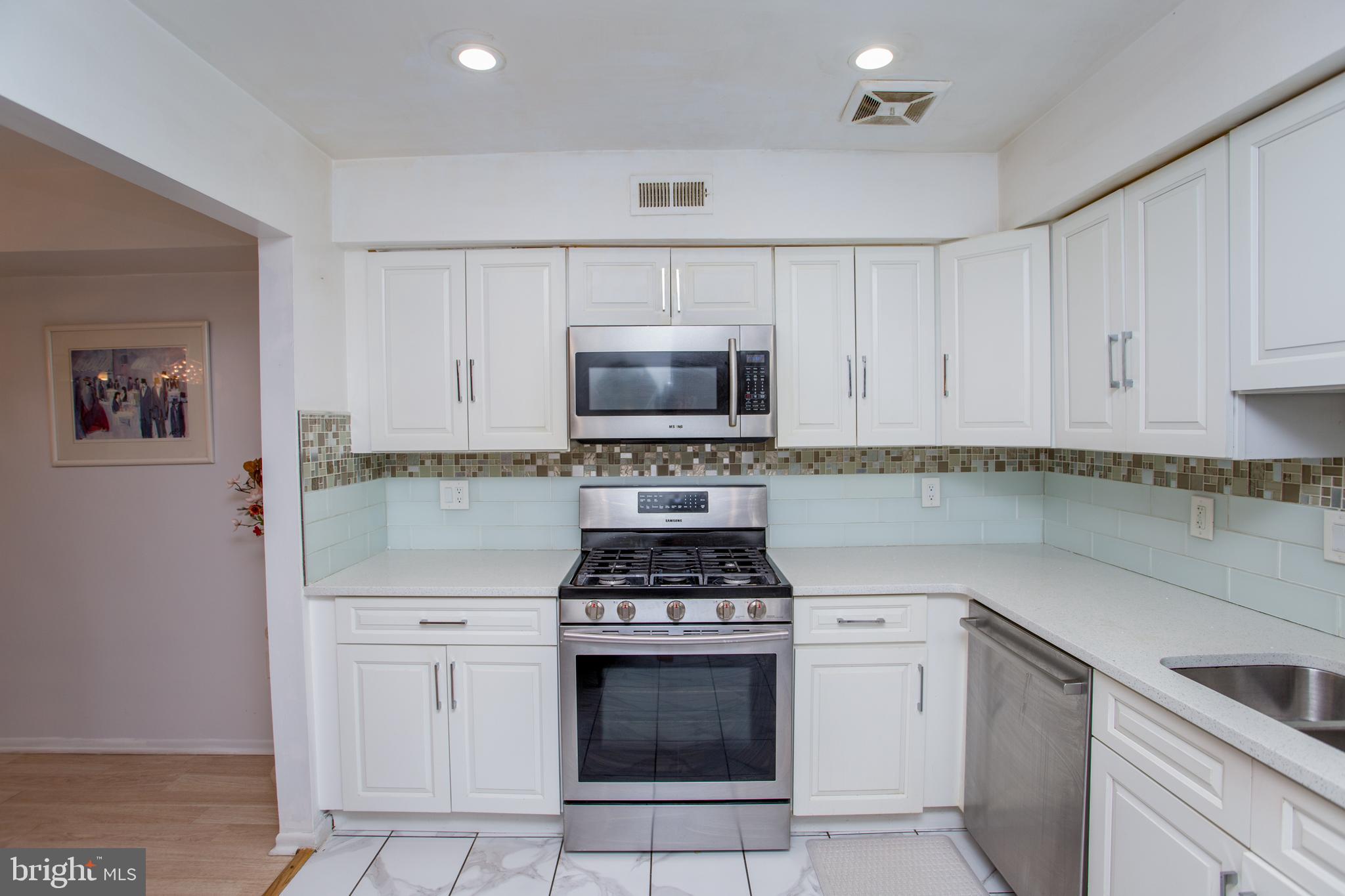 48 Bonnie Gellman Court, Unit B48 Philadelphia, PA 19114 - Photo 23 of 70 a kitchen with white cabinets and appliances