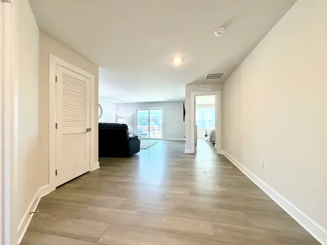 a view of a livingroom with wooden floor and furniture