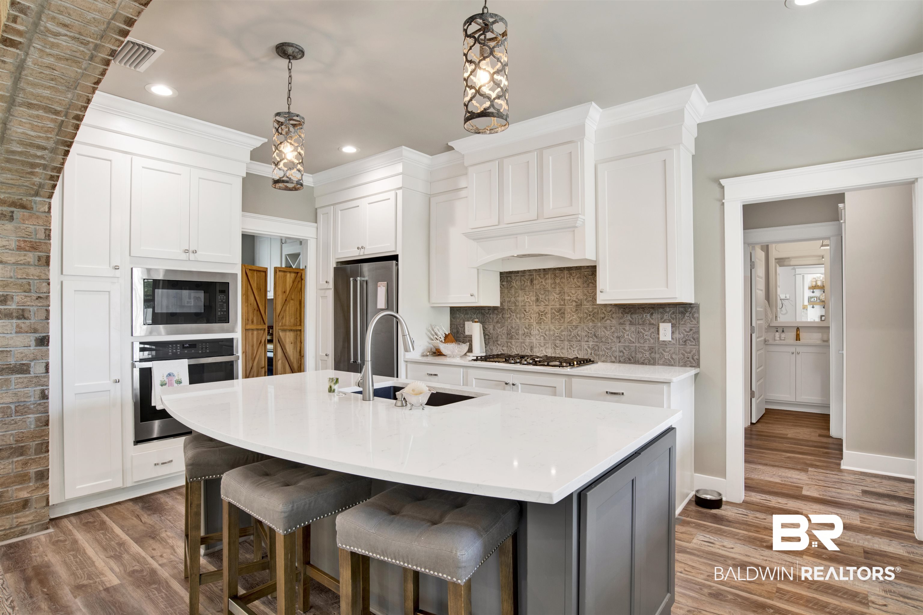21621 Veranda Boulevard Fairhope, AL 36532 - Photo 32 of 51 Kitchen with stainless steel appliances, visible vents, a sink, and wood finished floors