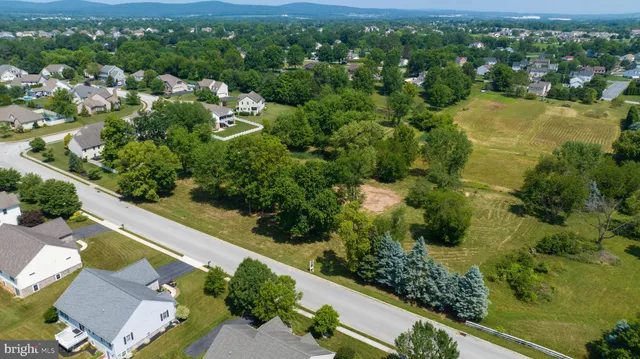 an aerial view of residential houses with outdoor space and trees