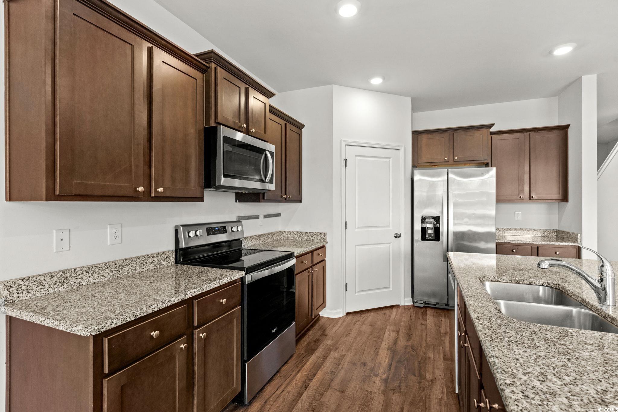 2631 Ophelia Way Myrtle Beach, SC 29577 - Photo 8 of 40 Kitchen with appliances with stainless steel finishes, dark wood-style floors, light stone counters, dark brown cabinets, and recessed lighting