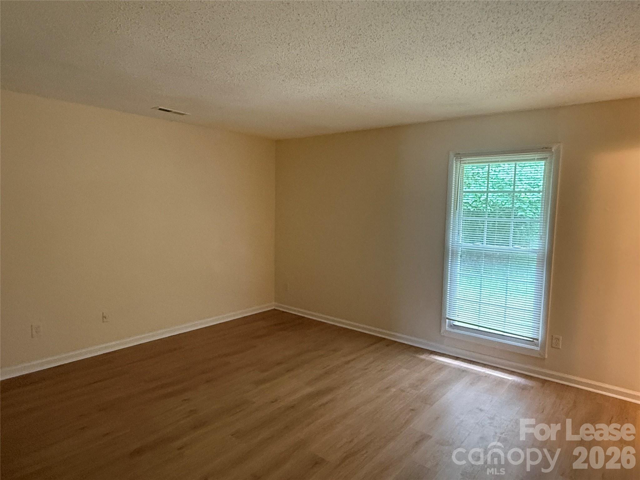 6341 Round Hill Road Charlotte, NC 28211 - Photo 8 of 16 an empty room with wooden floor and windows