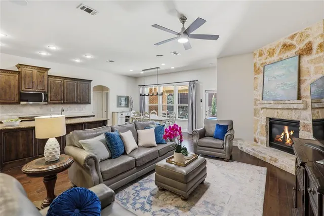 a living room with furniture a fireplace and a ceiling fan