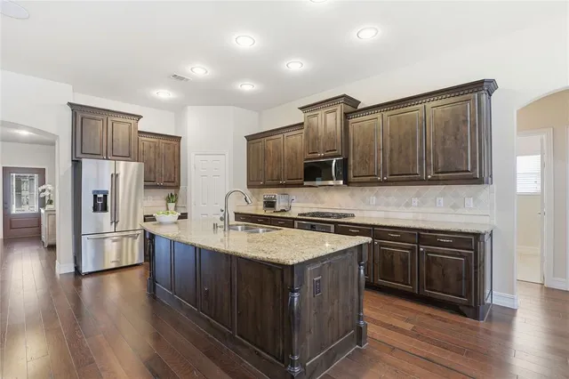 a kitchen with stainless steel appliances granite countertop a stove and cabinets
