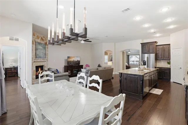 a kitchen with kitchen island a stove a table and chairs in it