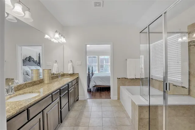 a bathroom with a granite countertop sink a toilet a mirror and bathtub