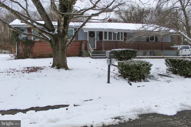 a front view of a house with a yard covered in snow