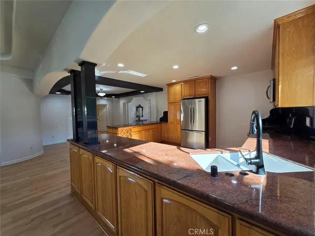 a kitchen with stainless steel appliances granite countertop a sink and a refrigerator