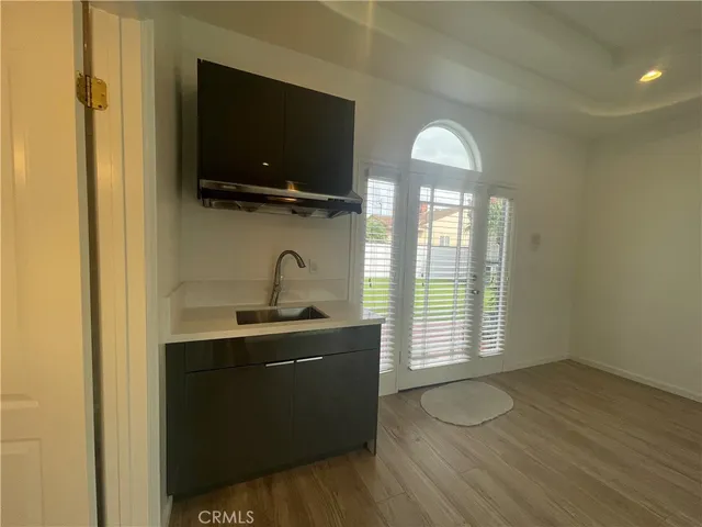 a kitchen with a sink and wooden floor