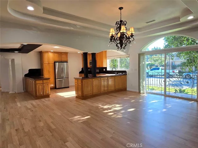 a view of a kitchen with granite countertop a sink stainless steel appliances and cabinets