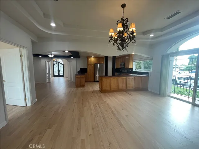 a view of a big room with wooden floor and windows