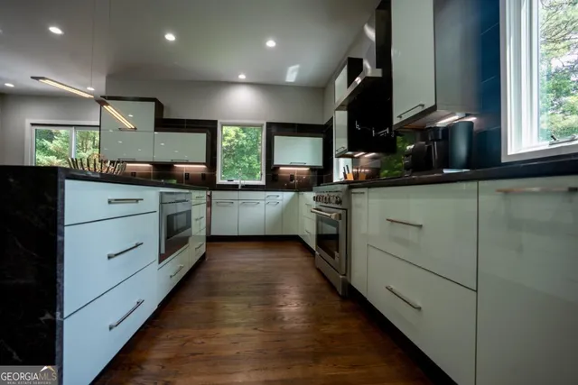 a kitchen with stainless steel appliances kitchen island granite countertop a stove and a sink