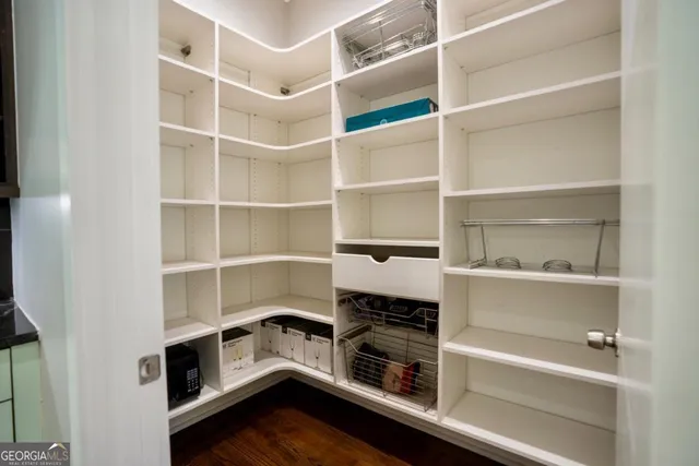 a room with a closet and wooden shelves