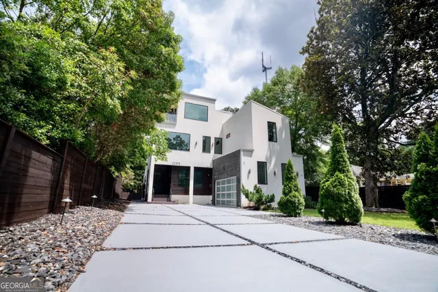 a view of a white house with a large tree