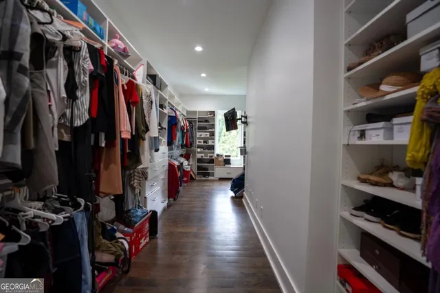 a view of walk in closet with clothes and shoes