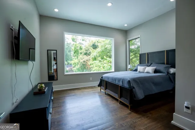 a bedroom with a bed and a flat tv screen on the dresser
