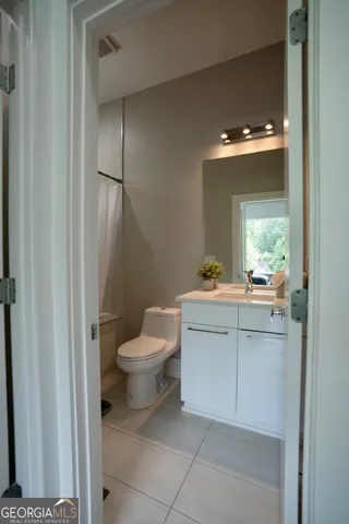 a bathroom with a toilet sink and mirror