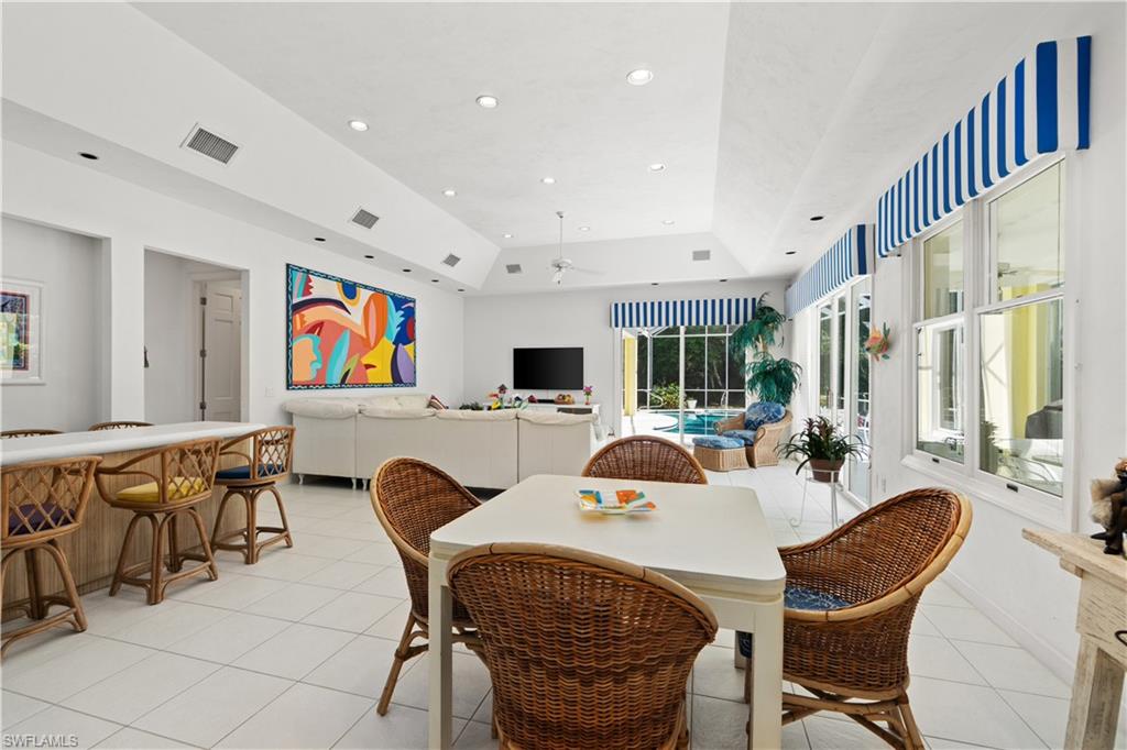 736 Ashburton Drive Naples, FL 34110 - Photo 12 of 37 a living room with furniture a flat screen tv and a large window