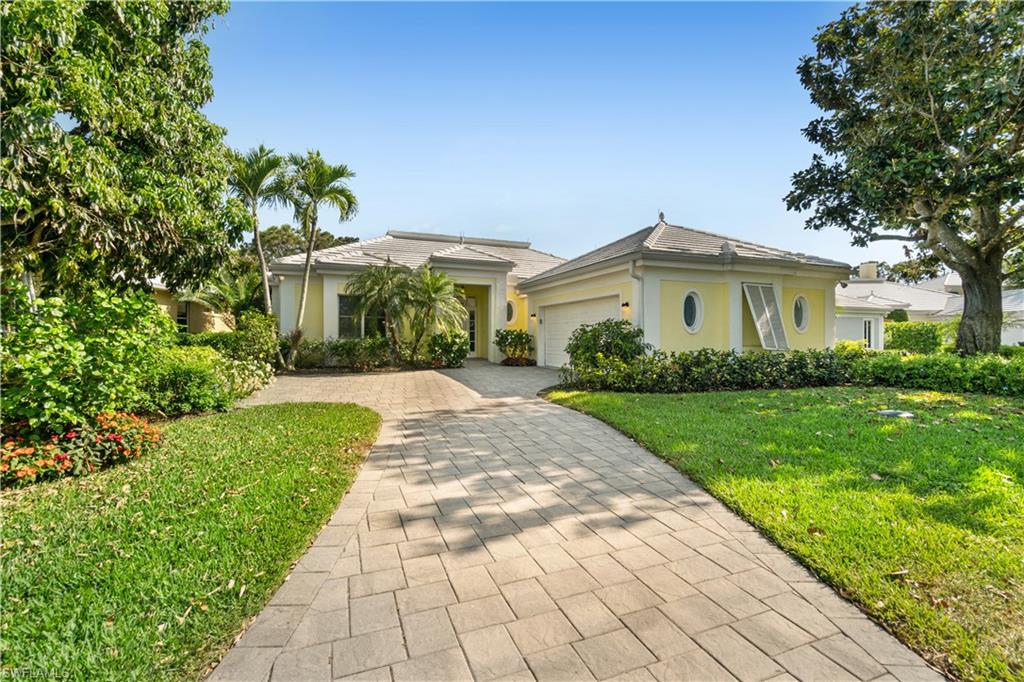 736 Ashburton Drive Naples, FL 34110 - Photo 2 of 37 a front view of a house with a garden
