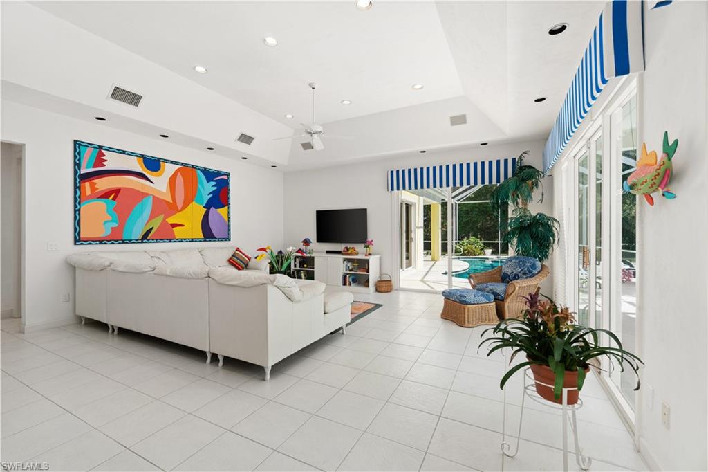 736 Ashburton Drive Naples, FL 34110 - Photo 3 of 37 a living room with furniture a flat screen tv and a chandelier