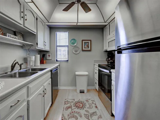 a kitchen with stainless steel appliances granite countertop white cabinets a stove a sink and dishwasher