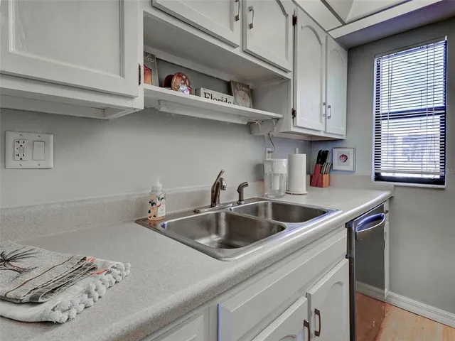a kitchen with white cabinets and appliances