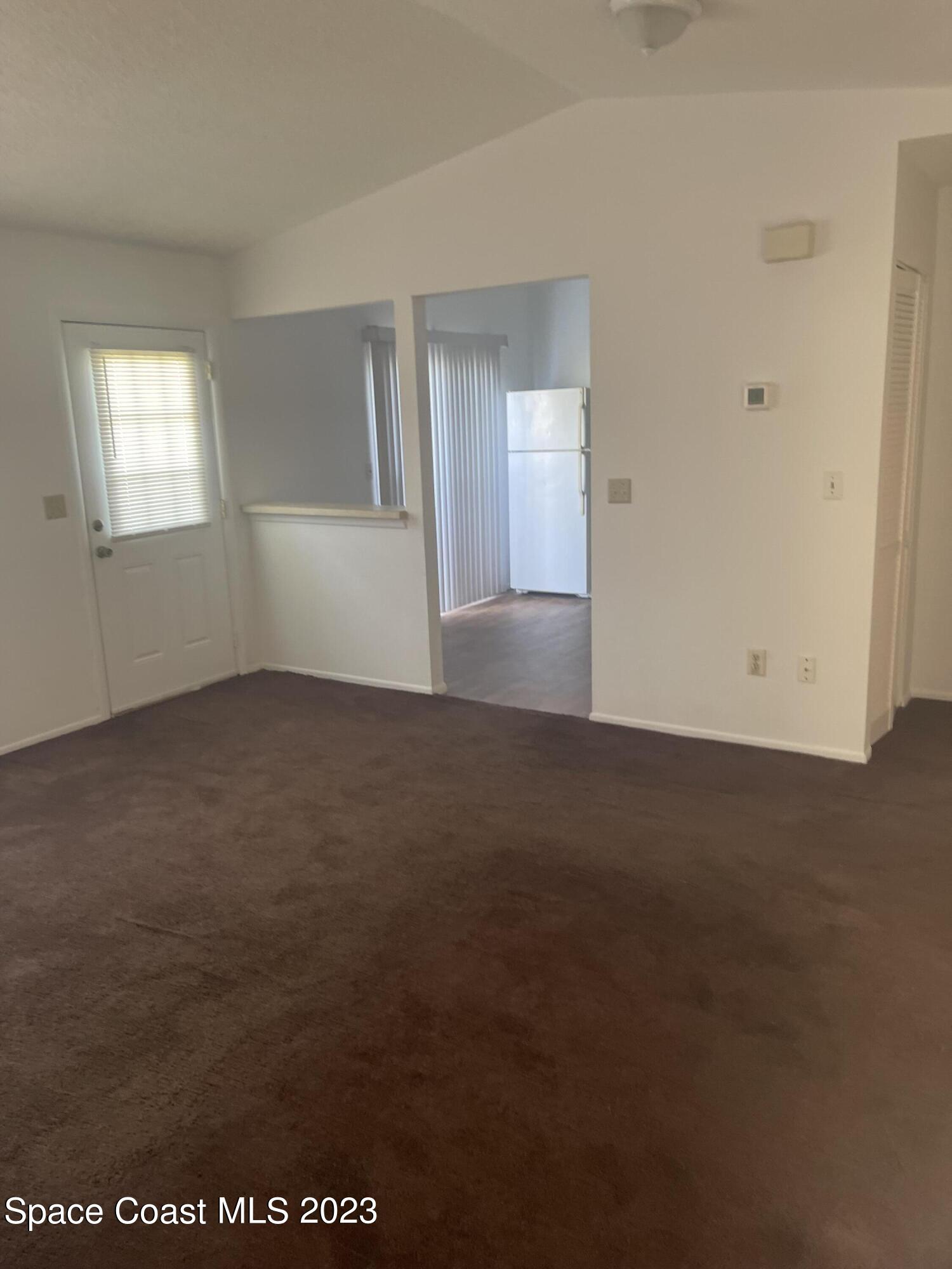 1485 Malibu Circle Northeast, Unit 101 Palm Bay, FL 32905 - Photo 4 of 9 an empty room with windows