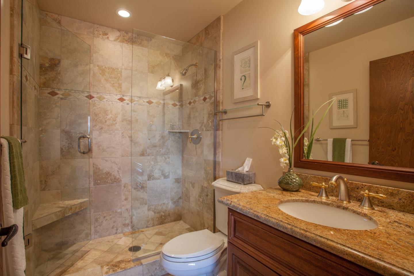 13987 Pike Road Saratoga, CA 95070 - Photo 15 of 28 a bathroom with a granite countertop sink a toilet a mirror and shower