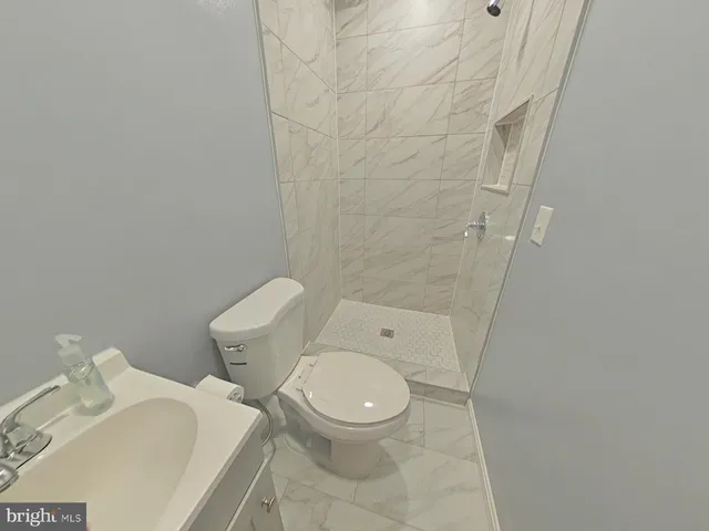 a white toilet sitting next to a shower