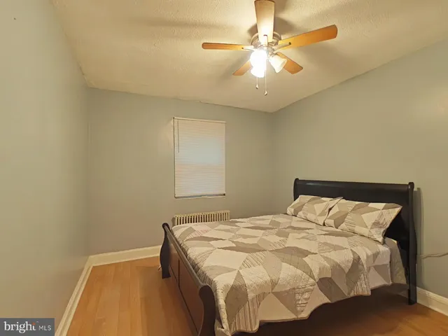 a bedroom with a bed and a ceiling fan