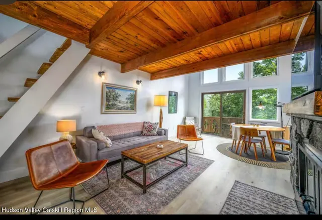 a living room with furniture a fireplace and a large window