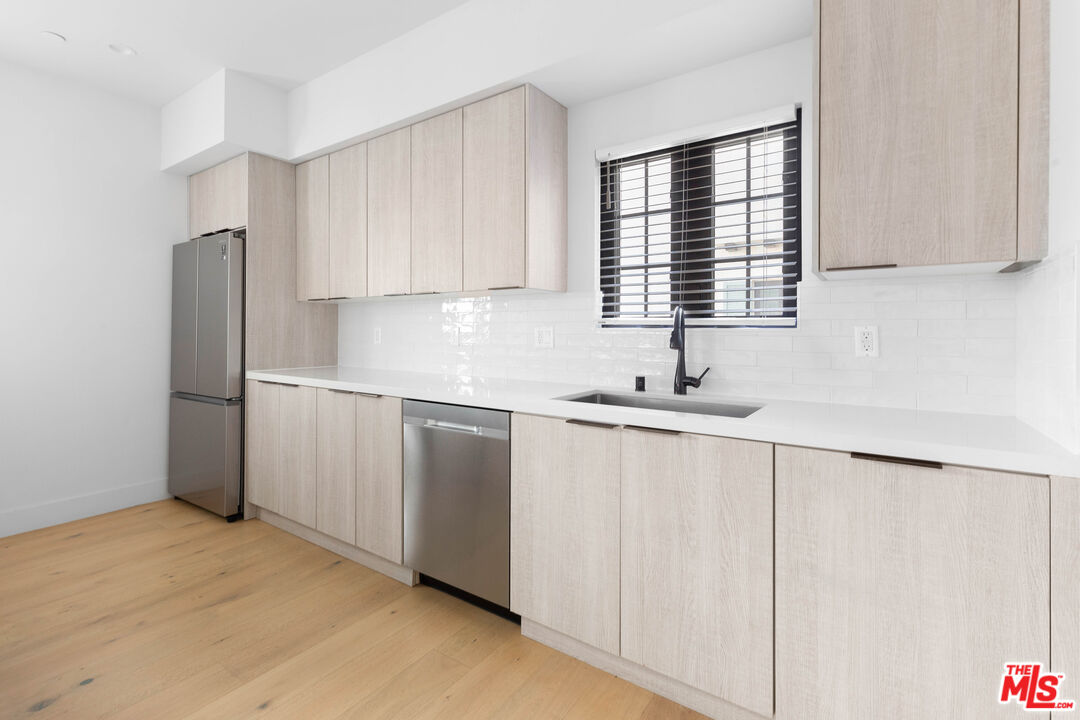 736 Parkman Avenue Los Angeles, CA 90026 - Photo 14 of 34 a kitchen with stainless steel appliances white cabinets and a sink