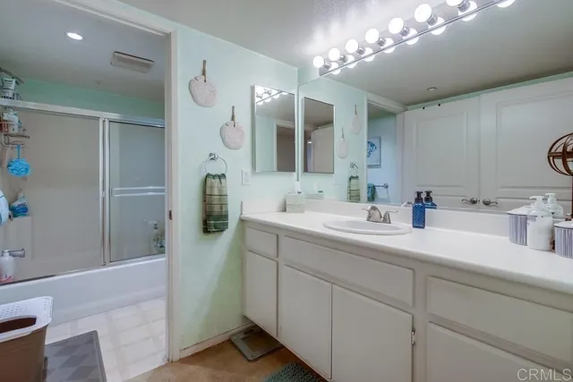 a bathroom with a double vanity sink mirror and shower