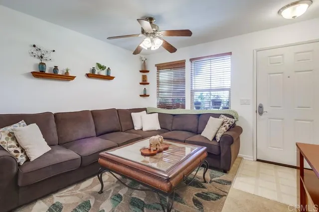 a living room with furniture a ceiling fan and a window